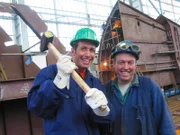 Zusammen mit einem Mitarbeiter der Nordseewerke erkundet Willi (links) die Emdener Schiffswerft.