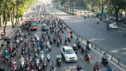 Große Straße mit Autos, Bussen, Motorrädern und Rollern