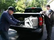 Brian takes a crowbar to the safe they found at the demo site.