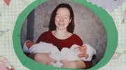 Eine lächelnde Frau hält zwei Babys in ihren Armen.