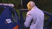 Ein Mann steht neben einem Polizeiauto