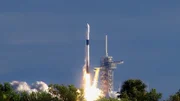 Eine Trägerrakete startet ins All. Sie transportiert einen Satelliten ins All.