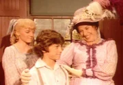 Mrs. Oleson (Katherine MacGregor, r.) stellt sich und ihre Kinder (Jonathan Gilbert, M., Alison Arngrim, l.) der neuen Lehrerin vor ...