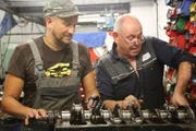 Fuzz Townshend and another member of staff work on the Jaguar XK engine.