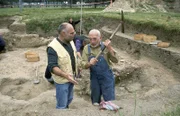 Peter (Peter Lustig, r.) packt an. Auf einer Ausgrabungsstätte schwingt er die Hacke, wird aber von einem der Experten (Ludger Burmann, l.) gestoppt. Peter erfährt von ihm mehr über alte Scherben und das Leben der Römer.