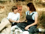 Hand in Hand sitzen Jim Bob Walton (David W. Harper, l.) und die Klosterschülerin Mary Frances (Stacey Nelkin, r.) im Gras von Waltons Mountains. Für ihn ist es die erste Liebe, und auch sie scheint mehr als Sympathie für ihn zu empfinden.