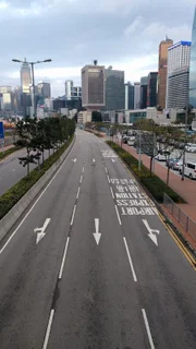 Eine leere Straße in Hongkong, China, im Hintergrund die Hochhäuser der Stadt.