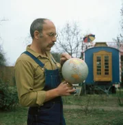 Peter Lustig erkennt auf dem Globus, dass es viele Länder auf der Welt gibt.