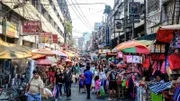Impression: Straßenszene mit vielen Menschen und Verkaufsständen in einer Straße der philippinischen Hauptstadt Manila.