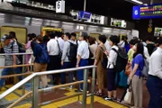 Schlange stehen zum Einsteigen in einen Nahverkehrszug in Hakata Station.