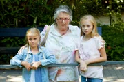 Frieda (Faye Esser, l.) und Lotta (Laila Ziegler, r.) sind mit ihrer Oma (Trish Patricia Osmond) im Zoo und müssen erschreckende Szenen mit ansehen.