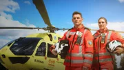 zwei Personen stehen neben einem Hubschrauber auf dem Boden