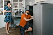 Paketbote Hannes Winkler (Steffen Wolf, r.) versucht, den Aktenschrank im B&uuml;ro von Miriam Stockl (Marisa Burger, l.) zu reparieren.