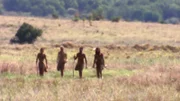 Vier der ursprünglich zwölf Teilnehmer gehen in einem Feld spazieren.