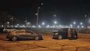 Mariana van Zeller talking to a masked subject in a parking lot.