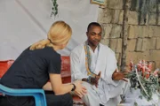 Mariana van Zeller (foreground L) talking with a masked individual.