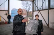 Eine Verpackung für Textilien - Lukas Petersen (Patrick Abozen, l.) und Nina Sieveking (Wanda Pedelwitz, r.) wundern sich, was es damit auf sich hat.