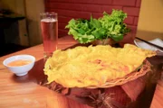 „Banh Xeo“ wird normalerweise zu besonderen Anlässen gegessen und ist ein mit Kurkuma gewürzter Reis-Crêpe, gefüllt mit Schweinefleisch, Garnelen, Mungobohnen und Sojasprossen, serviert hier mit frischem Gemüse und gesüßter Fischsauce im „Banh Xeo Muoi Xiem“ in der Nähe des Rucksacktouristenviertels von Ho-Chi-Minh-Stadt.