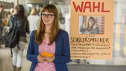 Lilli (Alina Stiegler) kandidiert bei der Wahl zur Schülersprecherin und verteilt Flyer.