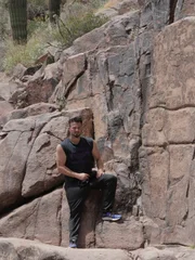 Justin standing in front of a wall full of petroglyphs.