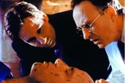 Mulder (David Duchovny, l.) und der Gerichtsmediziner (Laurie Murdoch, r.) finden einen merkwürdigen Holzsplitter im Hals des toten Mr. Balocchi (Gardiner Millar, M.).