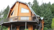 Exterior, house, at Lodge House, complete with wood siding, wrap around deck, two car garage, stairs up to front door, near Juneau, Alaska, as seen on Great American Country's Living Alaska