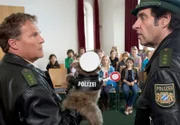 Spezialeinsatz im Schullandheim: Hubert (Christian Tramitz, l.) und Staller (Helmfried von Lüttichau, r.) erklären einer Schulklasse mit einer Handpuppe die Verkehrsregeln.