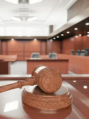 Interior of an empty courtroom with gavel and sounding block on the desk.