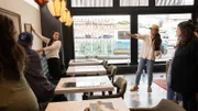 Jo hangs artwork in the seating area of the restaurant as seen on episode 105 of Fixer Upper: Hotel.