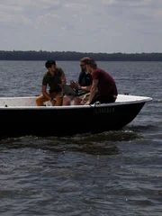Justin and Emiliano sitting on a fan boat speaking with an expert.
