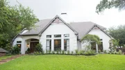 The exterior of the Bufton home has been updated with white paint, new windows, decorative cedar gables under the roof and fresh landscape, as seen on Fixer Upper.