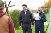 Jakob (Max König, M.) und Paul (Tim Wilde, r.) statten den Wennings (Nico Liersch, l.) mit einem Durchsuchungsbeschluss einen Besuch ab.