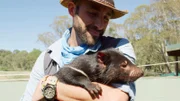 Coyote Peterson holds a tasmanian devil.