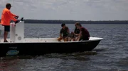 Wide shot of Justin and Emiliano sitting on a fan boat speaking with an expert.