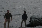 Justin and Emiliano standing on rocks over-looking the water.