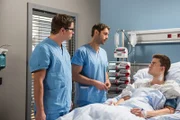 Daniel Ruland (Patrick Moelleken, r.) hat den riskanten Morbus-Crohn-Eingriff gut überstanden. Dr. Ahrend (Roy Peter Link, M.) und Elias Baehr (Stefan Ruppe, l.) klären ihn über die weiteren Schritte auf.