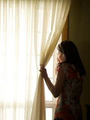 Eddie's mom Celia looking out the window covering her mouth