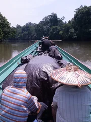 A canoe packed with gear moves down the river in Borneo.