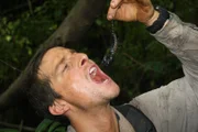 Bear Grylls holding up a scorpion, about to eat it, in Vietnam.