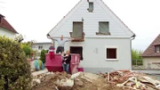 Anja und Alex mit den beiden Kindern vor ihrem Schnäppchenhaus