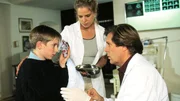 Dr. Stefan Frank (Sigmar Solbach) behandelt den kleinen Patrick Lehberger (Philippe Betrand). Sprechstundenhilfe Marie Luise (Christiane Brammer) assistiert ihm.