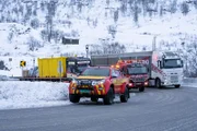 Thord und Erlend schneiden dem Dänen die Ketten ab und befestigen sie. Der dänische Fahrer hat Ice Road Rescue gesehen und fragt sich, wie Thord es schafft, in der Kälte ohne Handschuhe zu arbeiten (National Geographic/ITV Studios Norway AS).
