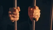 Eine Person hinter Gittern
