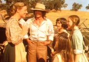 Caroline (Karen Grassle, l.) ist überglücklich. Denn in dem Telegramm kündigen ihre Eltern einen Besuch in Walnut Grove an. Auch Albert (Matthew Laborteaux, 3.v.l.) und Charles (Michael Landon 2.v.l.) freuen sich die Großeltern kennen zu lernen.