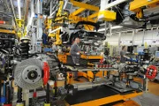 Factory workers prepare for the marriage of the Porsche body and engine.