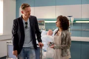 Piet Wellbrook (Peter Fieseler, l.) und Harry (Maria Ketikidou, r.) wundern sich - warum vermisst niemand Heinrich Fischer (im HG), der seit Monaten im Krankenhaus im Koma liegt?
