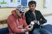 Martin (Hans Sigl, r.) amüsiert sich über seinen Freund Kahnweiler (Mark Keller, l.), dem die anstehende Untersuchung so peinlich ist, dass er sich maskiert hat.