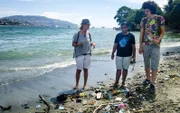 Die Passagiere Silke und Cosmo Hümmer (Mutter und Sohn) sammeln mit Eco Bricks Mitarbeiterin Müll am Strand entlang von Ambon in Indonesien ein. Die Plastikflaschen dienen als Baumaterial für Häuser, Möbel, etc.