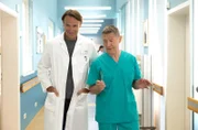 Dr. Rolf Kaminski (Udo Schenk, re.) erzählt Dr. Martin Stein (Bernhard Bettermann, li.), dass ihre gemeinsame Patientin mit ihm flirtet und um ein Kaffeetrinken gebeten hat. Außerdem sei sie angeblich doch nicht verheiratet.