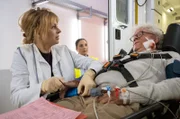 Hans Rehmann (Thomas Goritzki, re.) wird mit Brüchen und Brandwunden in die Sachsenklinik eingeliefert. Dr. Ina Schulte (Isabell Gerschke, li.) übernimmt die erste Sichtung und will dann Arzu Ritter die Anweisung geben, in welchen Bereich er zu bringen ist. Doch Hans hat große Sorge um einen jungen Mann, der ihn nach der Gasexplosion aus seinem Zimmer in der Rehaeinrichtung gerettet hat.